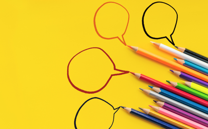 Different color pencils drawing speech bubbles