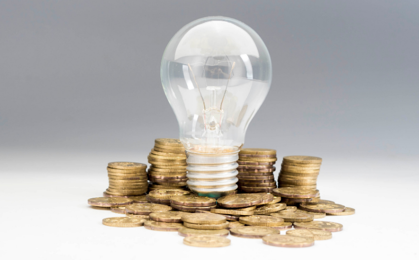 Idea lightbulb on pile of coins