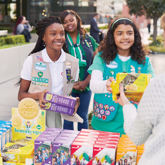 Girl Scouts happily handing out cookies