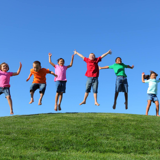 Children jumping happily on a hill