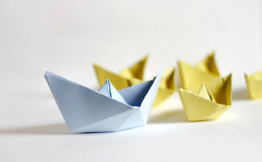 Paper sailboats moving in formation.